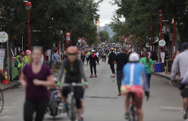 A blurred image of pedestrians, bicyclists and other using a city street for recreational activities
